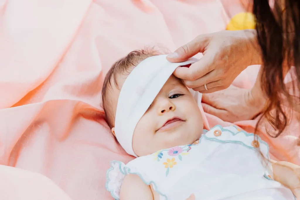 Bébé allongé sur un drap rose