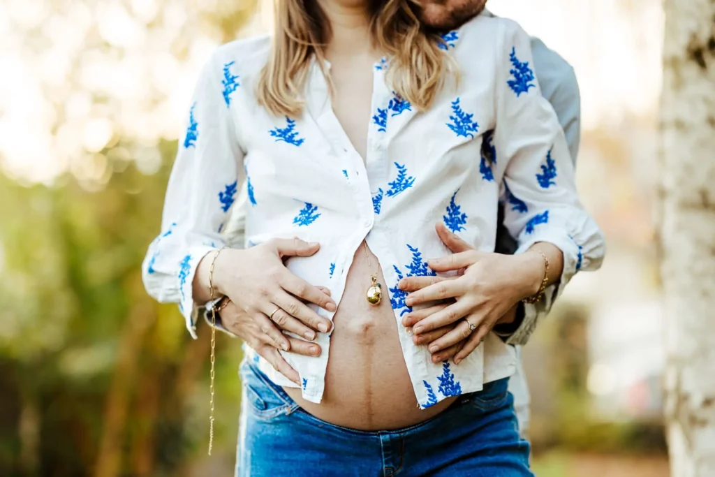 Shooting grossesse, couple à l'extérieur en automne