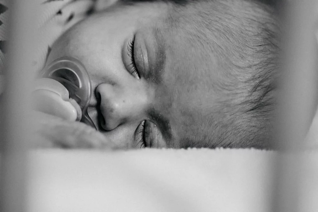 Gros plan d'un bébé qui dort en noir et blanc